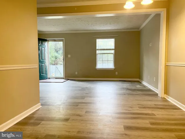a view of a livingroom with wooden floor and a window