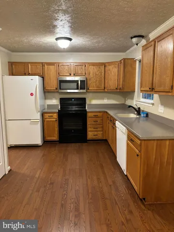 a large kitchen with stainless steel appliances granite countertop a stove a sink dishwasher and a refrigerator