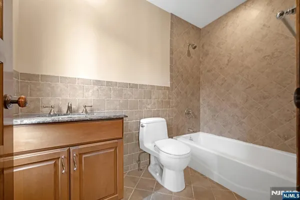 a kitchen with stainless steel appliances kitchen island granite countertop a refrigerator a sink dishwasher a dining table and chairs with wooden floor