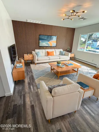 a living room with furniture and a wooden floor