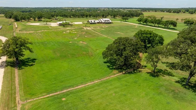 a view of a green field with wooden fence