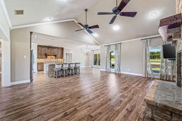 a kitchen with granite countertop a stove a sink dishwasher and a refrigerator with wooden floor
