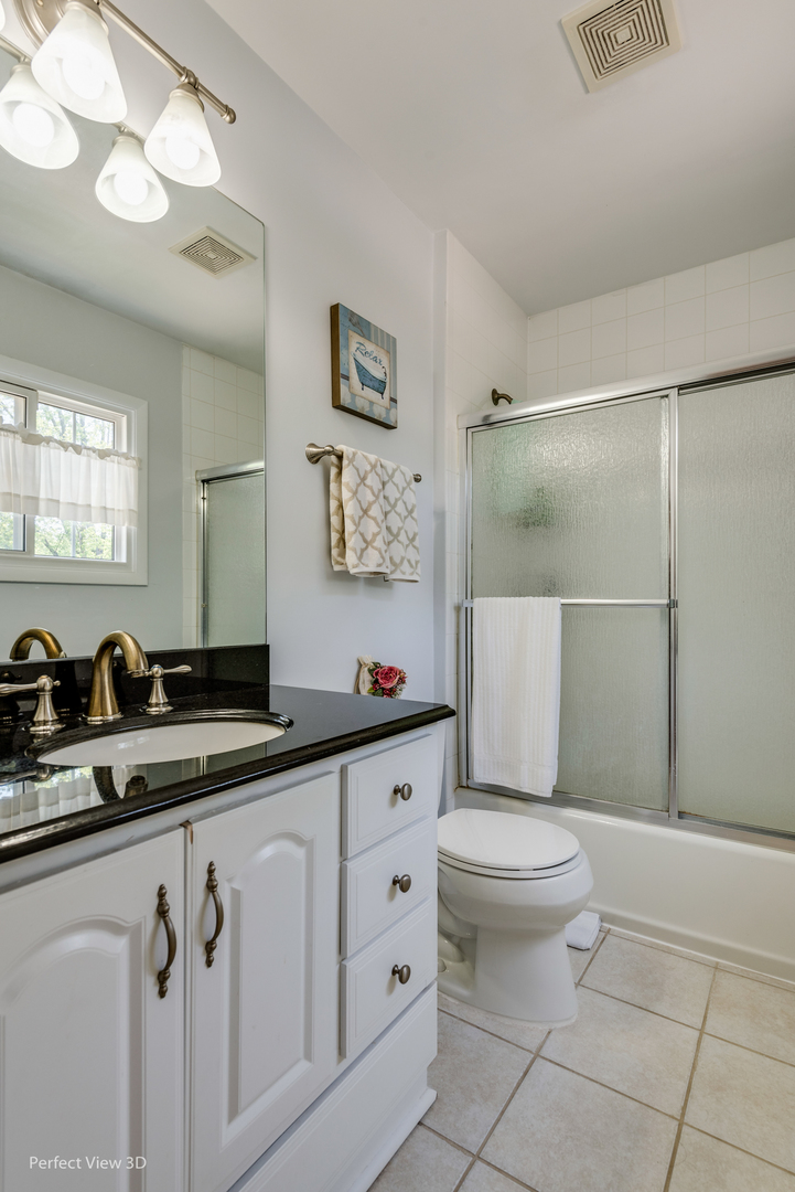 1825 Barberry Road Northbrook, IL 60062 - Photo 12 of 24 a bathroom with a granite countertop sink a toilet a mirror and shower