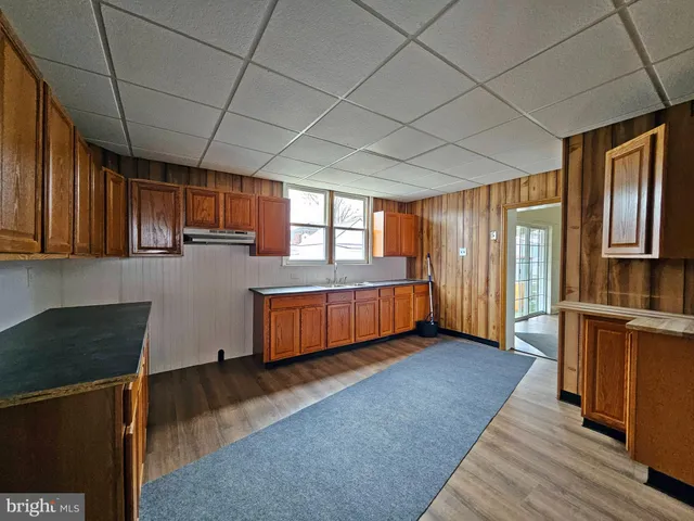 a view of a kitchen with wooden floor and electronic appliances