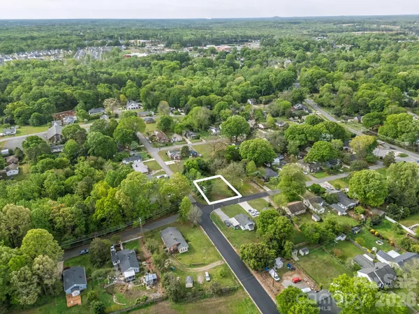 an aerial view of residential houses with outdoor space and trees