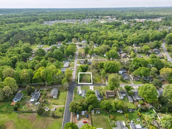 an aerial view of residential houses with outdoor space and trees