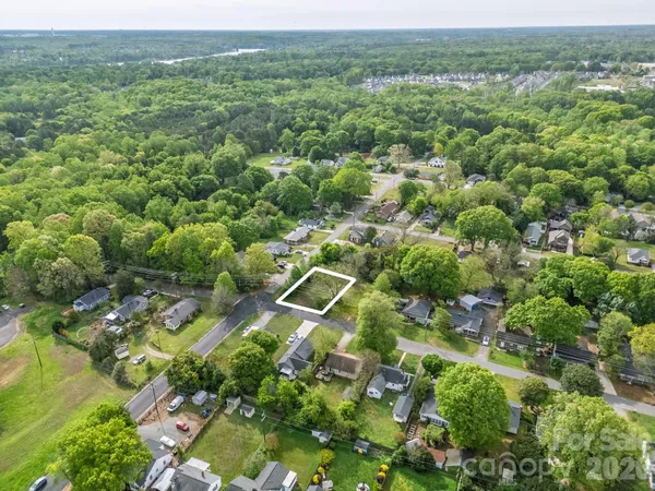 an aerial view of residential houses with outdoor space and trees