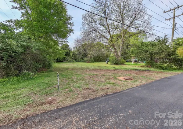 a view of a field with trees in the background