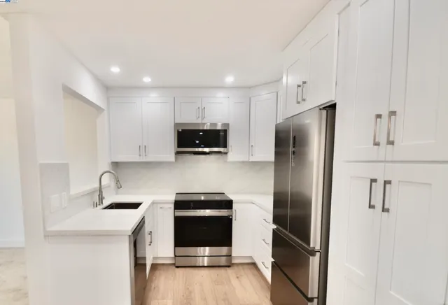 a kitchen with stainless steel appliances a refrigerator sink and microwave