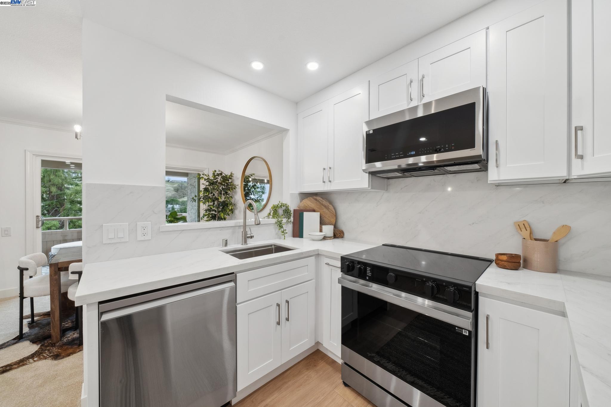 4033 Terra Granada Drive, Unit 5C Walnut Creek, CA 94595 - Photo 18 of 44 a kitchen with stainless steel appliances a stove microwave and sink