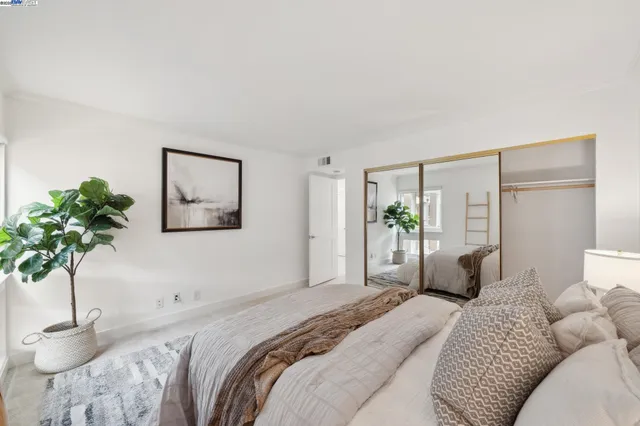 a bedroom with a large bed and a potted plant