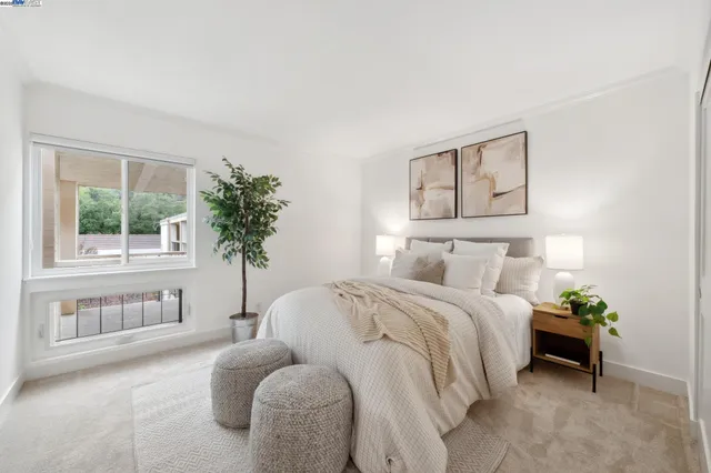 a bedroom with a bed and a potted plant