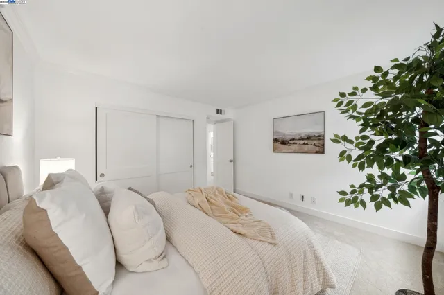 a bedroom with a large bed and a potted plant