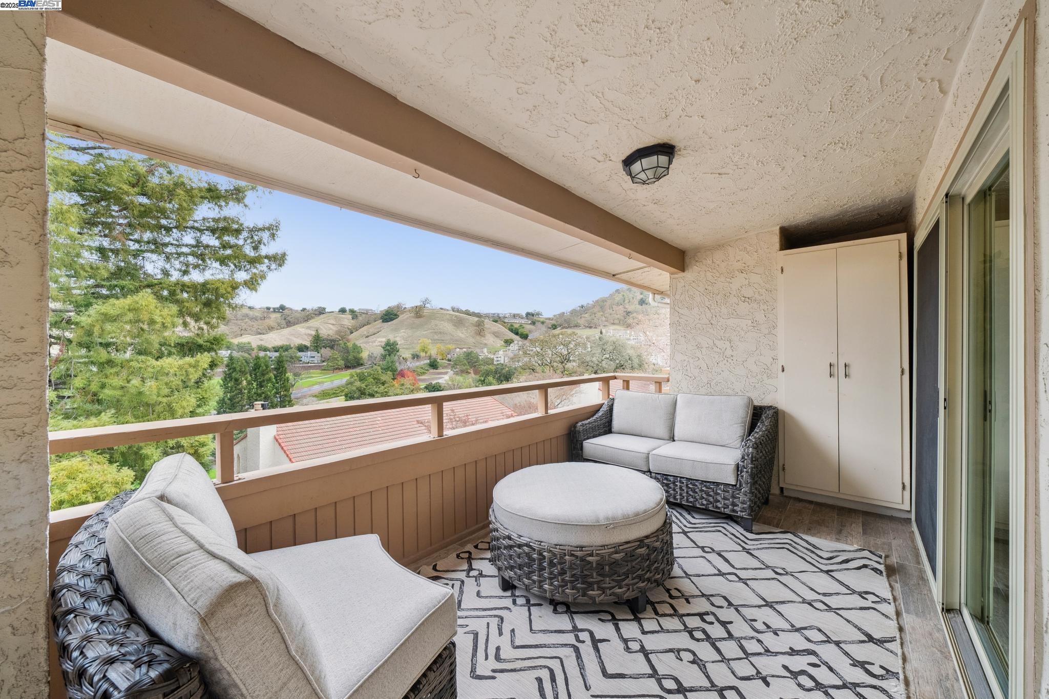 4033 Terra Granada Drive, Unit 5C Walnut Creek, CA 94595 - Photo 29 of 44 a living room with furniture a rug and a floor to ceiling window