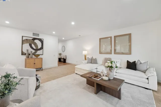 a living room with furniture a rug and white walls