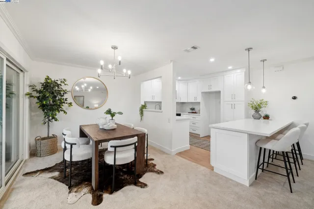 a kitchen with a table chairs a sink and cabinets