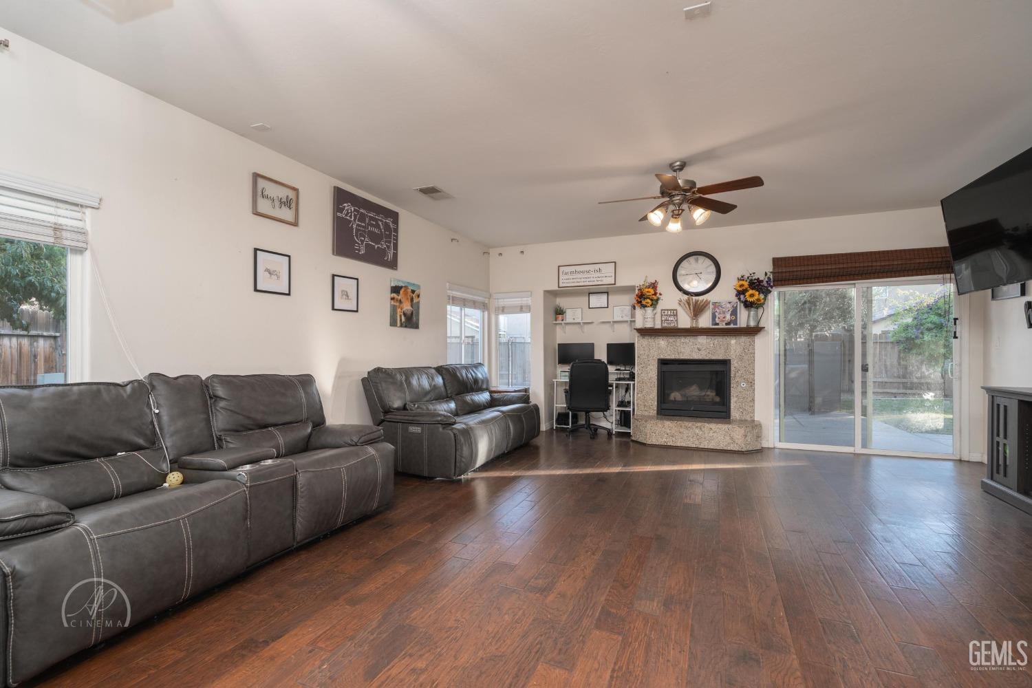 Undisclosed Address Bakersfield, CA 93312 - Photo 6 of 20 a living room with furniture a fireplace and wooden floor