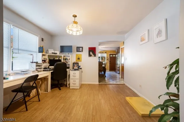 a view of a dining room with furniture a chandelier and wooden floor