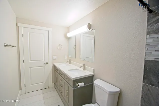 a bathroom with a granite countertop toilet sink and mirror