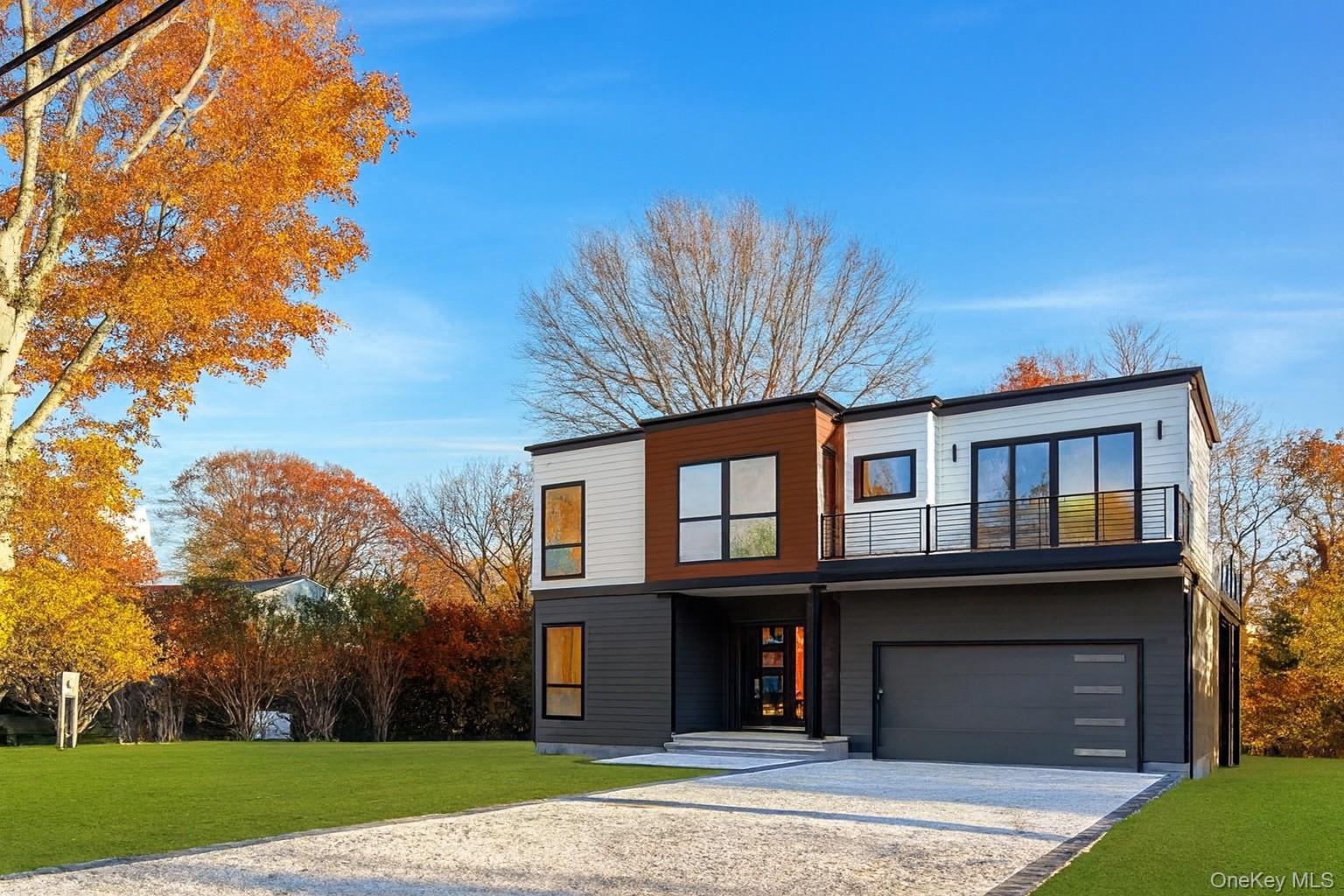 600 Glenn Road Southold, NY 11971 - Photo 1 of 1 Contemporary house featuring a front lawn, gravel driveway, and an attached garage