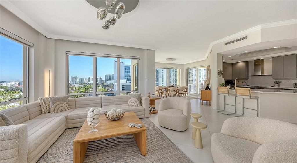 35 Watergate Drive, Unit 806 Sarasota, FL 34236 - Photo 25 of 67 a living room with furniture a large window and a chandelier