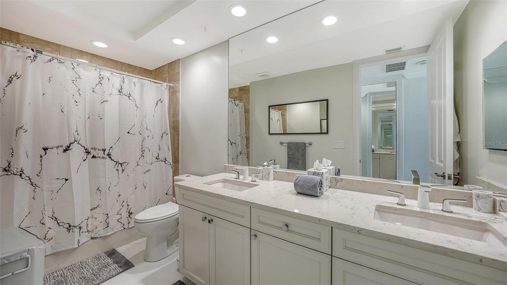 35 Watergate Drive, Unit 806 Sarasota, FL 34236 - Photo 50 of 67 a bathroom with double vanity sinks a toilet a mirror and shower