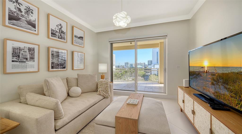 35 Watergate Drive, Unit 806 Sarasota, FL 34236 - Photo 51 of 67 a living room with furniture and a flat screen tv