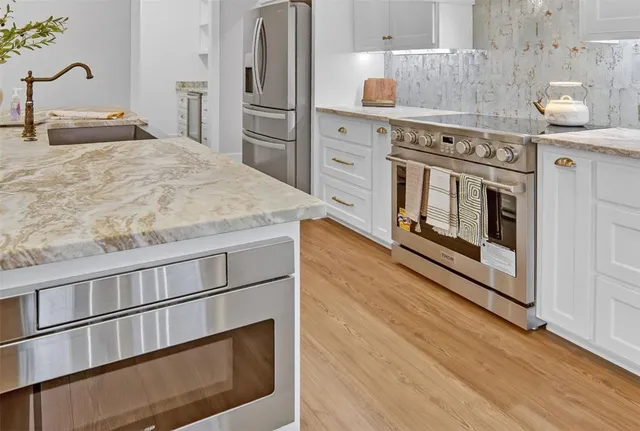 a kitchen with stainless steel appliances granite countertop a stove and a refrigerator