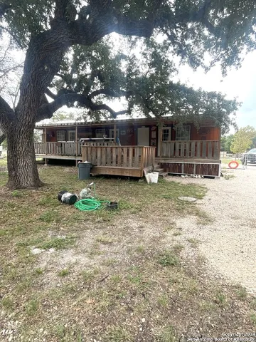 a view of dirt yard with a large tree