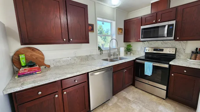 a kitchen with stainless steel appliances granite countertop a sink stove and microwave