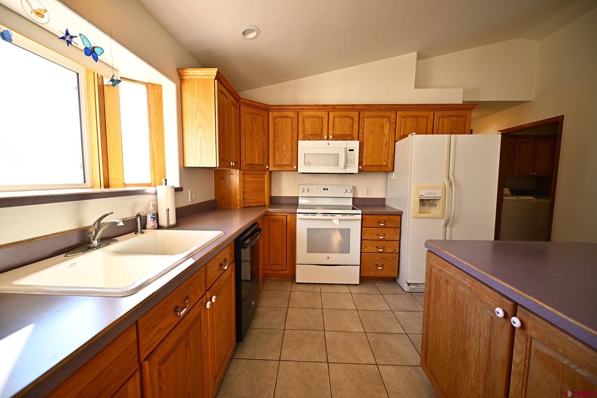 66750 Solar Road Montrose, CO 81403 - Photo 42 of 45 a kitchen with a sink a refrigerator and cabinets