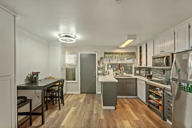 a kitchen with stainless steel appliances kitchen island granite countertop a sink stove and refrigerator