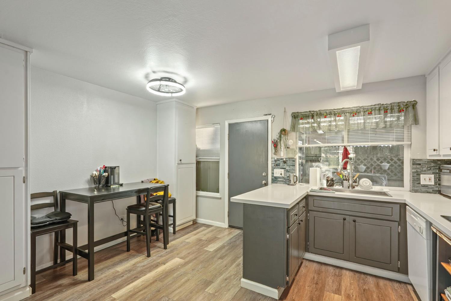 6103 Plymouth Road, Unit 1974 Stockton, CA 95207 - Photo 7 of 13 a kitchen with a sink chairs and cabinets