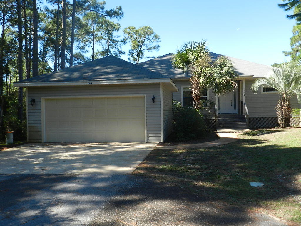 196 My Way Santa Rosa Beach, FL 32459 - Photo 1 of 26 a front view of a house with a yard and garage
