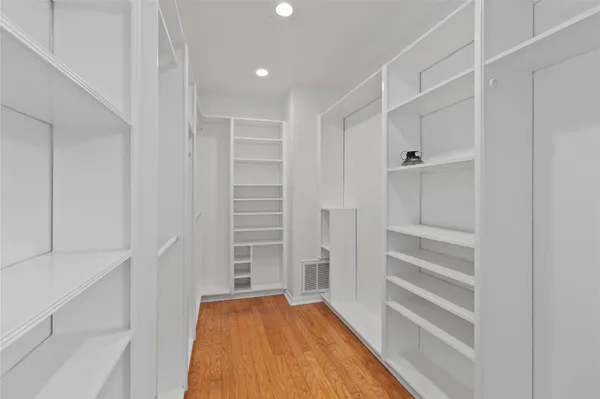 a view of walk in closet with empty racks