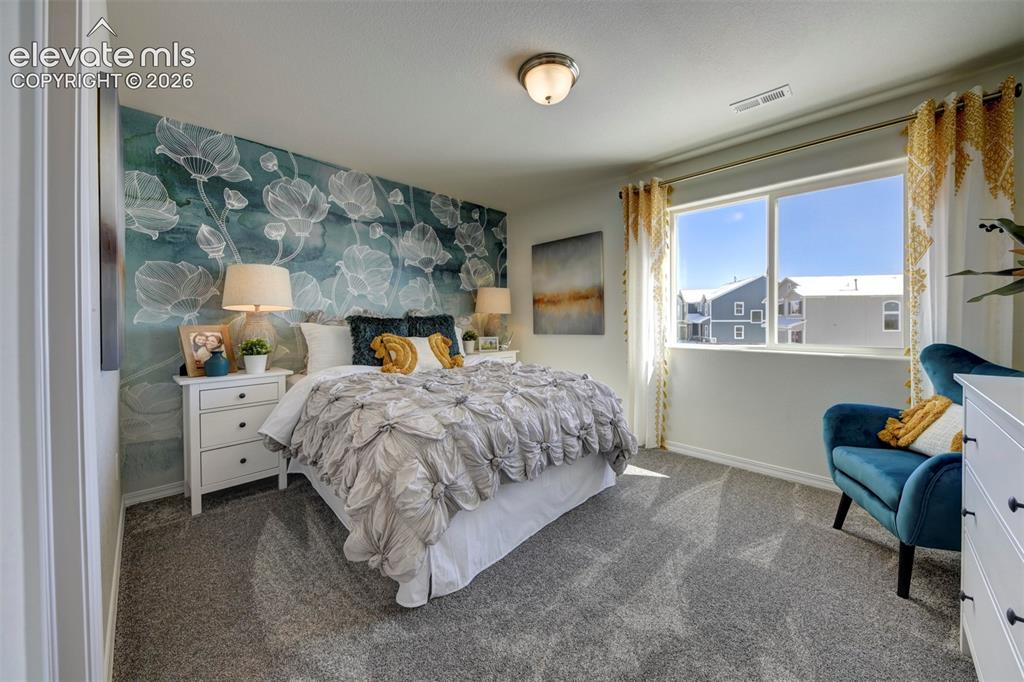 8230 Lemon Grass Road Falcon, CO 80831 - Photo 17 of 22 a bed room with a bed and a chair