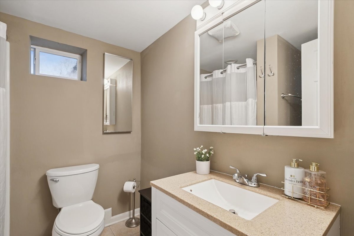 689 East Illinois Road Lake Forest, IL 60045 - Photo 15 of 18 a bathroom with a toilet sink and mirror