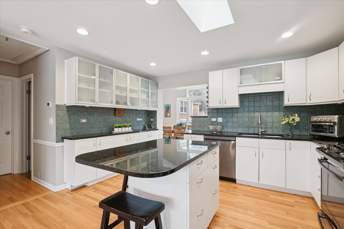 689 East Illinois Road Lake Forest, IL 60045 - Photo 3 of 18 a kitchen with stainless steel appliances granite countertop a sink a stove a microwave a center island and chairs