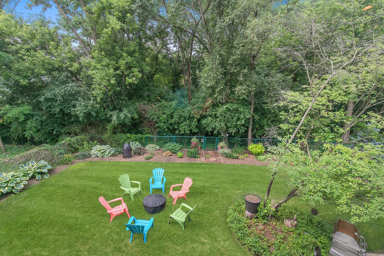 606 Old Hunt Road Fox River Grove, IL 60021 - Photo 30 of 35 a backyard of a house with table and chairs plants and large trees