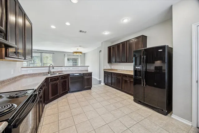 a kitchen with stainless steel appliances granite countertop a stove a sink and a refrigerator