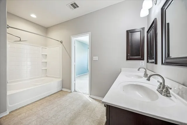 a bathroom with a bathtub sink and mirror