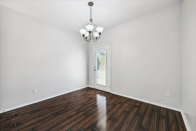 a view of room with wooden floor and chandelier