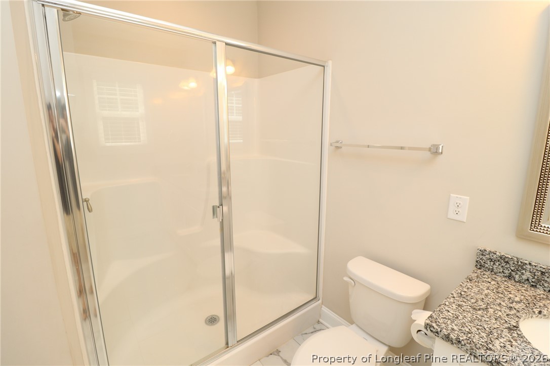 8424 Rhodes Road Apex, NC 27539 - Photo 21 of 31 a bathroom with a shower and a toilet