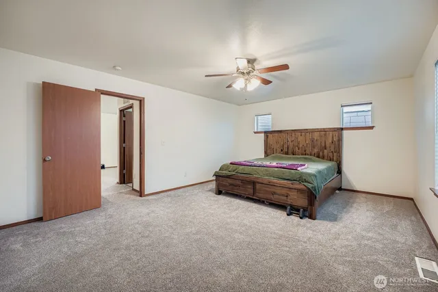 a bedroom with a bed and a ceiling fan