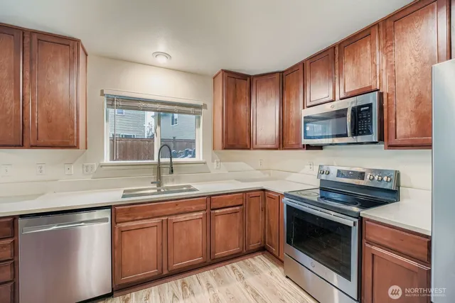 a kitchen with stainless steel appliances granite countertop a sink stove and microwave