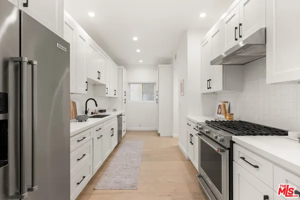 a kitchen with stainless steel appliances a sink stove and cabinets