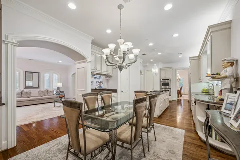 a view of a dining room and livingroom with furniture wooden floor a chandelier