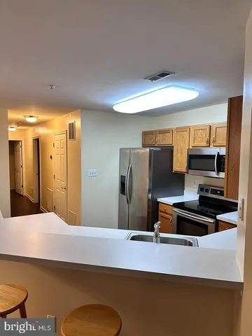 a kitchen with stainless steel appliances a refrigerator and a stove