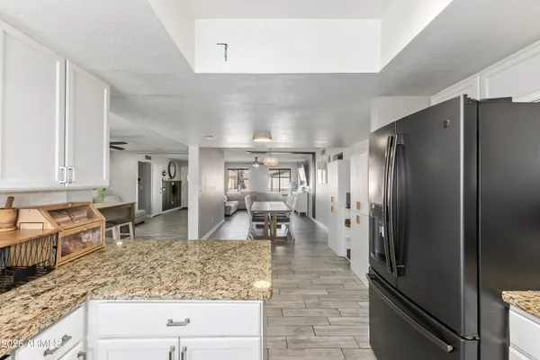 a large kitchen with stainless steel appliances granite countertop a refrigerator and a sink