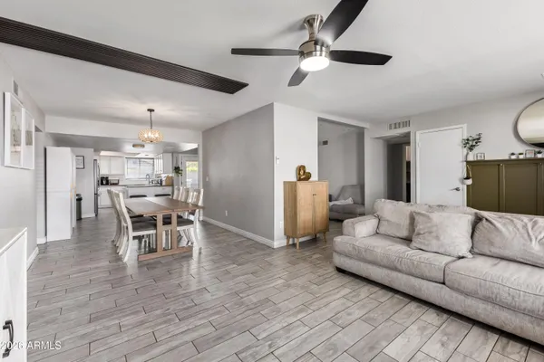 a living room with furniture and a view of kitchen